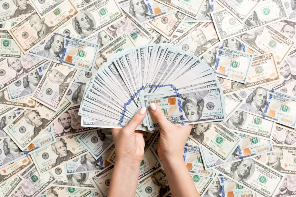 Person holding hundreds of large denomination bills because they have made it to the hyperaccumulation stage of Money Guy's 9 Step Financial Order of Operations